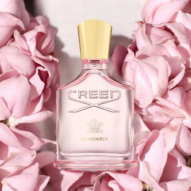Creed Eladia perfume bottle on pink flowers