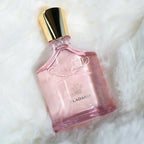 Pink perfume bottle with gold cap on a white fur background