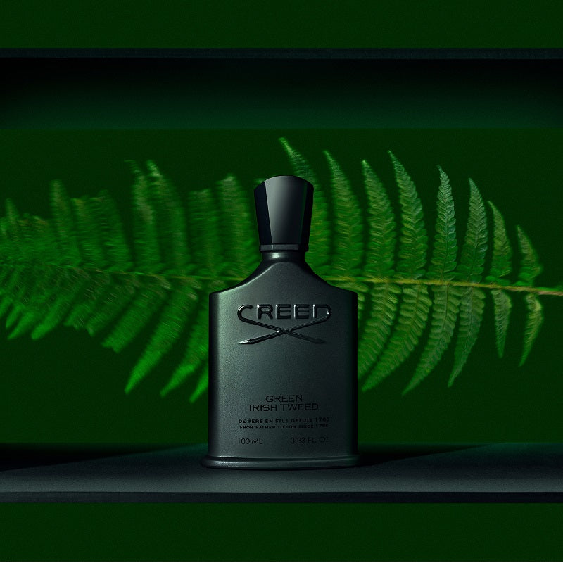 Creed Green Irish Tweed perfume bottle with fern leaves in the background