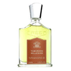 A bottle of Tabarome Millesime Eau de Parfum by Creed with a label in the center, predominantly in a clear glass bottle with a silver cap.