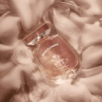 Perfume bottle labeled 'Wind Flowers' by Creed on a floral background