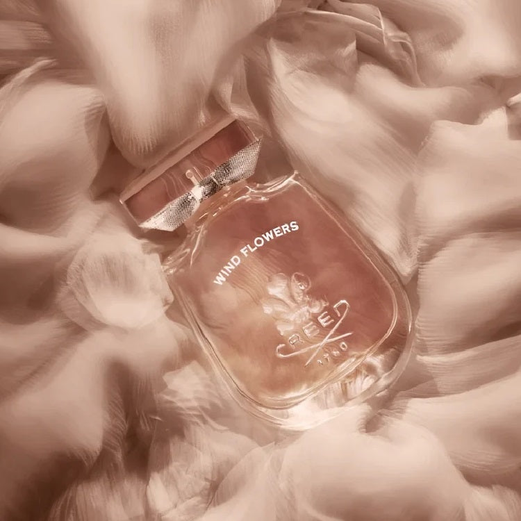 Perfume bottle labeled 'Wind Flowers' by Creed on a floral background