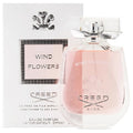 A bottle of Creed Wind Flowers Eau De Parfum with its packaging, displaying the product name and fragrance notes.