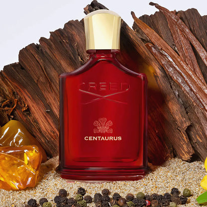 Red Creed Centaurus perfume bottle with gold cap on a textured background