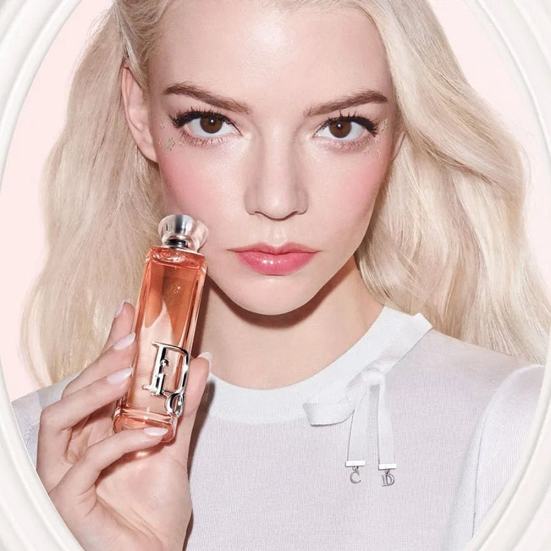 Woman holding a perfume bottle with a soft focus background