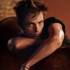 Man with a muscular arm resting on a surface, wearing a dark shirt.