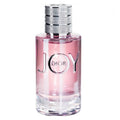 A glass bottle of Dior Joy Eau de Parfum with a pink liquid visible and the brand name 'Dior' inscribed on the bottle.