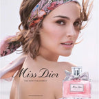 Woman wearing a floral headband with a Miss Dior perfume bottle in the foreground.