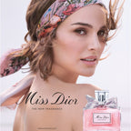 Woman wearing a floral headband with a bottle of Miss Dior perfume on a light background