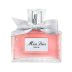 Bottle of Miss Dior Parfum with a silver bow on the cap, pink liquid visible through the clear glass, and label with 'Miss Dior PARFUM'.