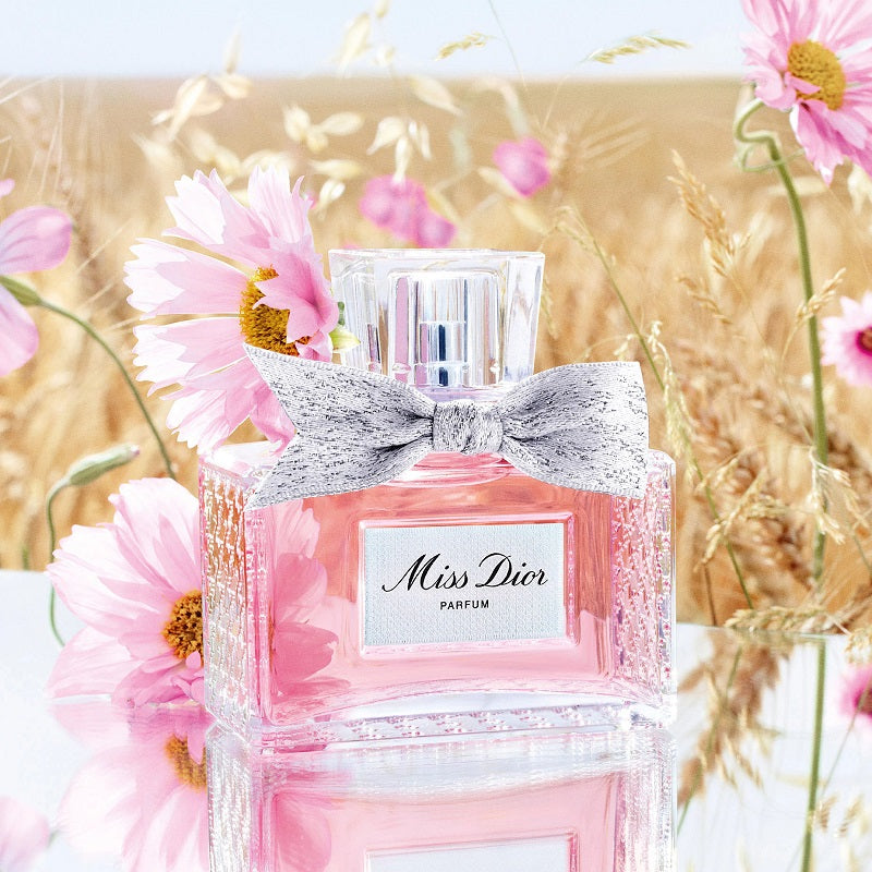 Miss Dior parfum bottle with pink flowers in the background