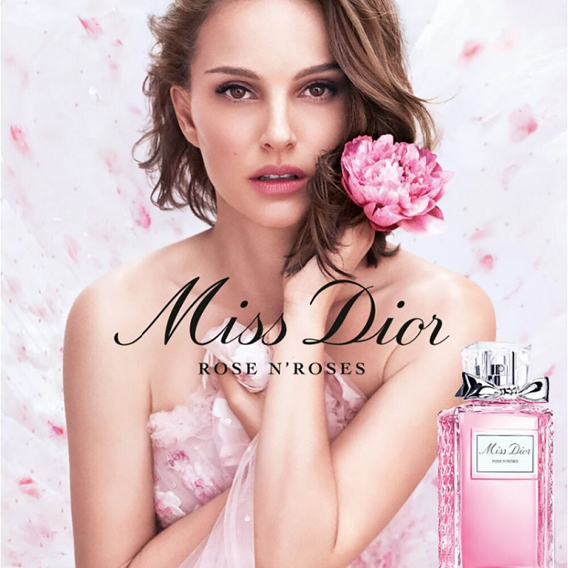 Model with a pink flower in hair and 'Miss Dior' perfume bottle on a soft pink background