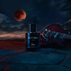 Dior Sauvage Elixir perfume bottle on a deep blue background and behind a guitar and the moon