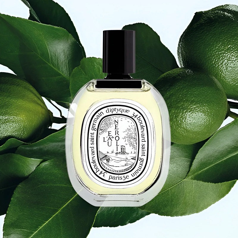 Diptyque perfume bottle with green leaves and limes in the background