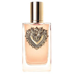 A glass bottle of Dolce Gabbana Devotion Eau de Parfum with a pink liquid visible and a decorative heart-shaped design on the top.