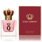 A product image featuring Dolce Q-Queen Eau de Parfum by Dolce Gabbana, with a glass bottle in pink hue topped with a golden crown and a matching red label, alongside the perfume box with the brand's logo.