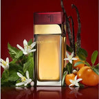 Dolce & Gabbana perfume bottle with flowers and oranges on a red background