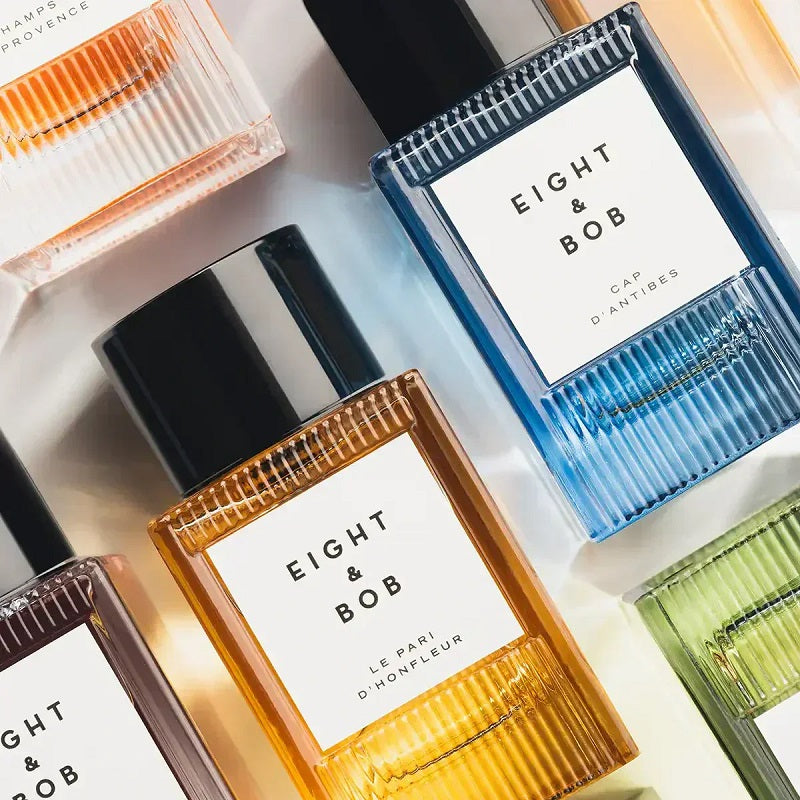 Collection of 'Eight & Bob' perfume bottles with different colored caps on a light background.