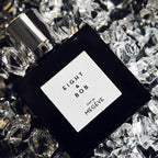 Perfume bottle labeled 'Eight & Bob' on a bed of clear crystals