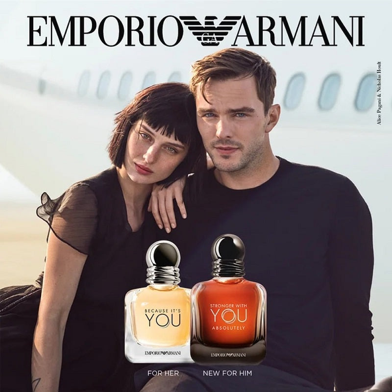 Advertisement for Emporio Armani perfume with a man and woman sitting next to two perfume bottles.