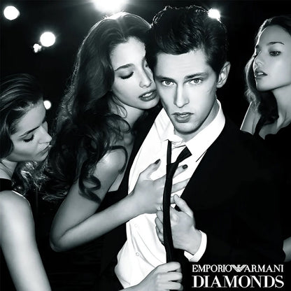 Black and white advertisement featuring a man in a suit with women around him, Emporio Armani Diamonds branding.