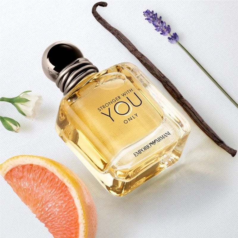 Perfume bottle labeled 'Stronger with You Only' by Emporio Armani with a vanilla bean, grapefruit, and lavender on a white background.