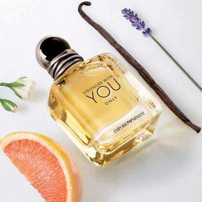 Perfume bottle labeled 'Stronger with You Only' by Emporio Armani with a vanilla bean, grapefruit, and lavender on a white background.