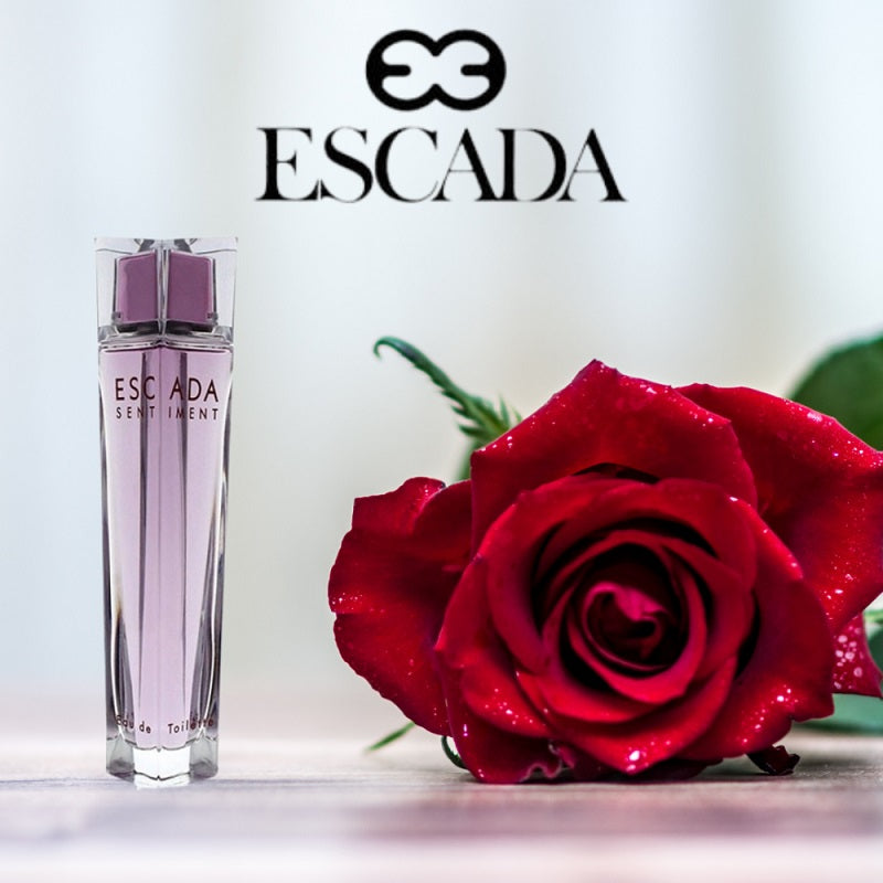 Escada perfume bottle with a red rose on a light background