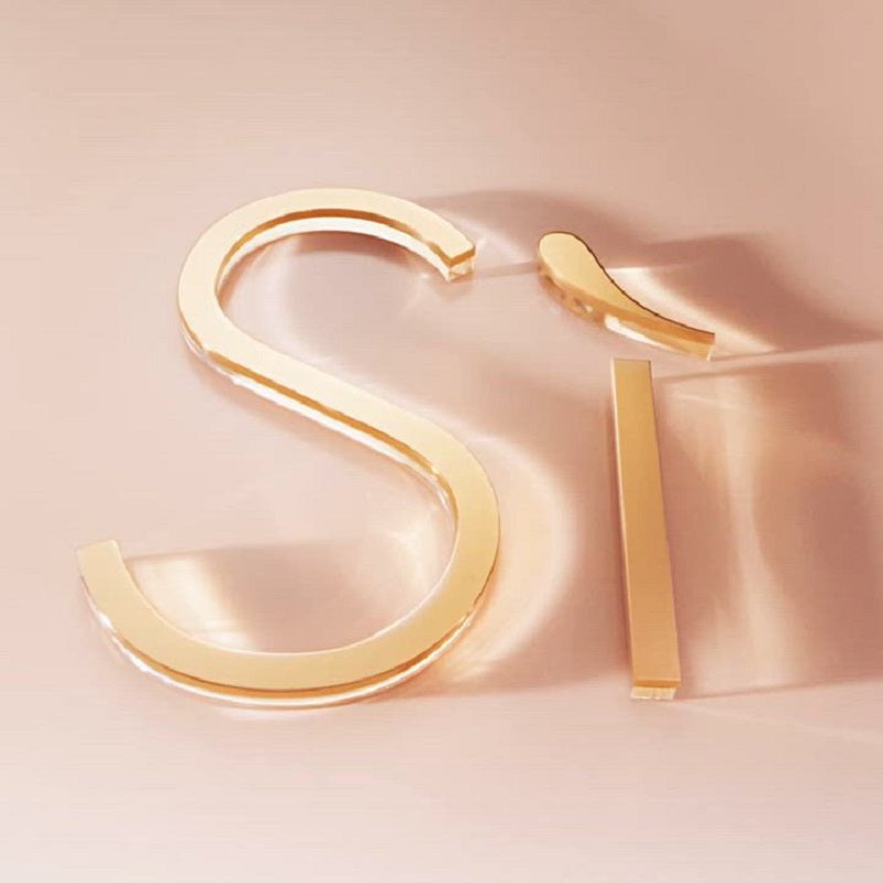 Gold hoop earrings on a soft pink background