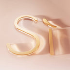 Gold hoop earrings on a soft pink background
