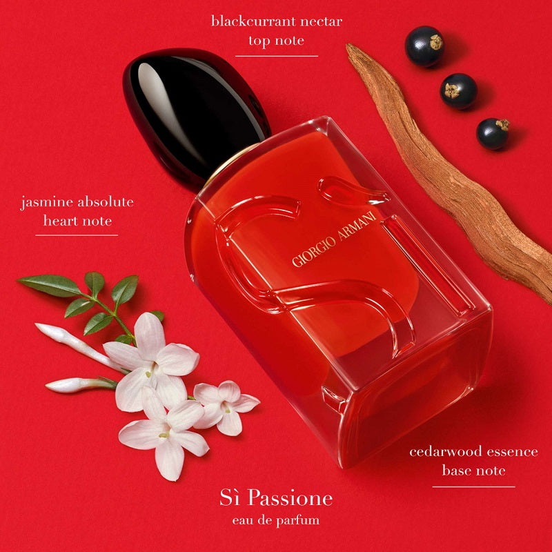 Red Giorgio Armani perfume bottle with floral and blackcurrant elements on a red background