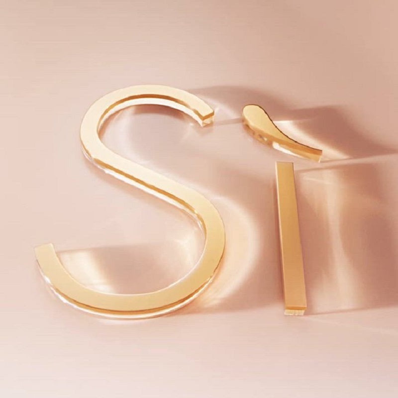 Gold hoop earrings on a soft pink background