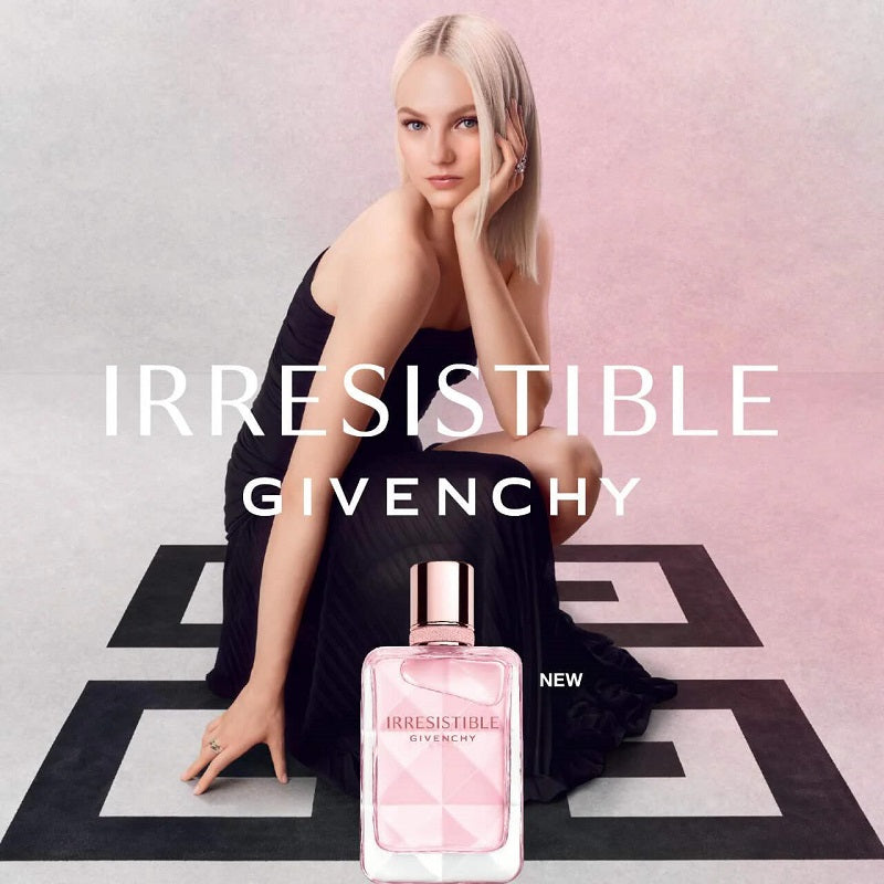 Model with Givenchy Irresistible perfume bottle on a geometric patterned floor.