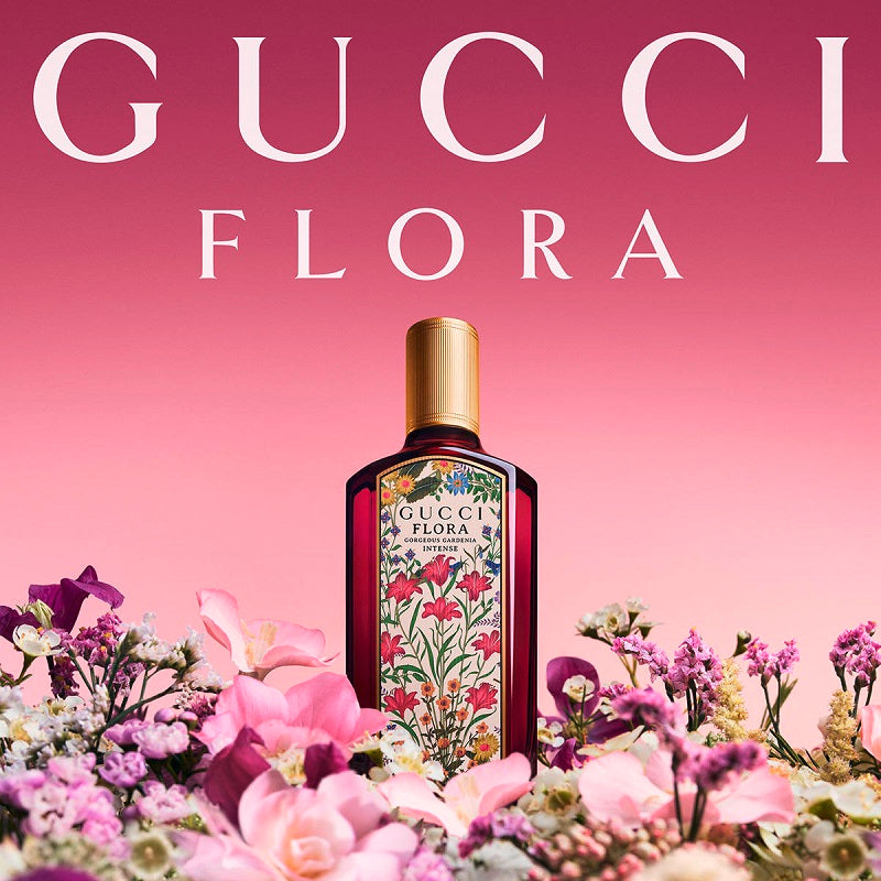 Gucci Flora perfume bottle surrounded by flowers on a pink background