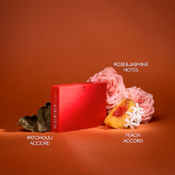 Red Gucci perfume box with flowers and fruits on an orange background