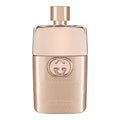 A spray bottle of Gucci Guilty Pour Femme eau de toilette with a gold-colored label and cap.