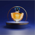 Shalimar perfume bottle on a blue platform with a dark blue background