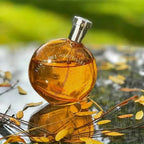 Perfume bottle labeled 'Elixir des Merveilles' with a blurred natural background