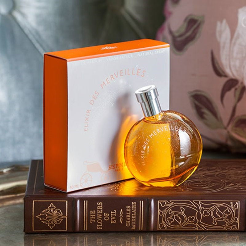 Perfume bottle and packaging on a decorative book with a floral background
