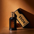 BOSS bottle and packaging on a wooden surface with a brown background