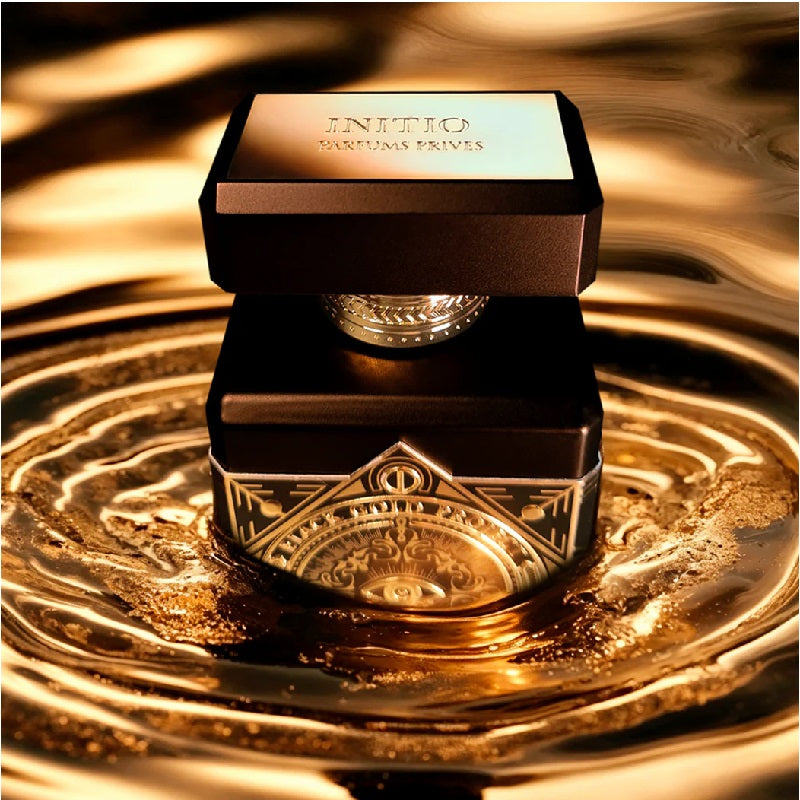 Gold perfume bottle and packaging on a reflective gold surface