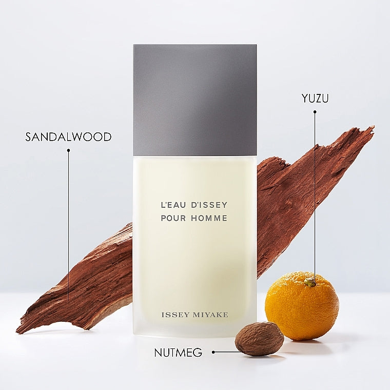Issey Miyake Leau Dissey Pour Homme perfume bottle with sandalwood, yuzu, and nutmeg elements on a light gray background