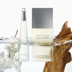 Two Issey Miyake L'Eau d'Issey Pour Homme perfume bottles on a decorative stand with white flowers and wooden elements.