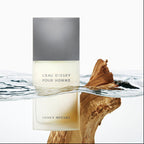 Issey Miyake L'Eau d'Issey Pour Homme perfume bottle on a white background with water and wood elements.