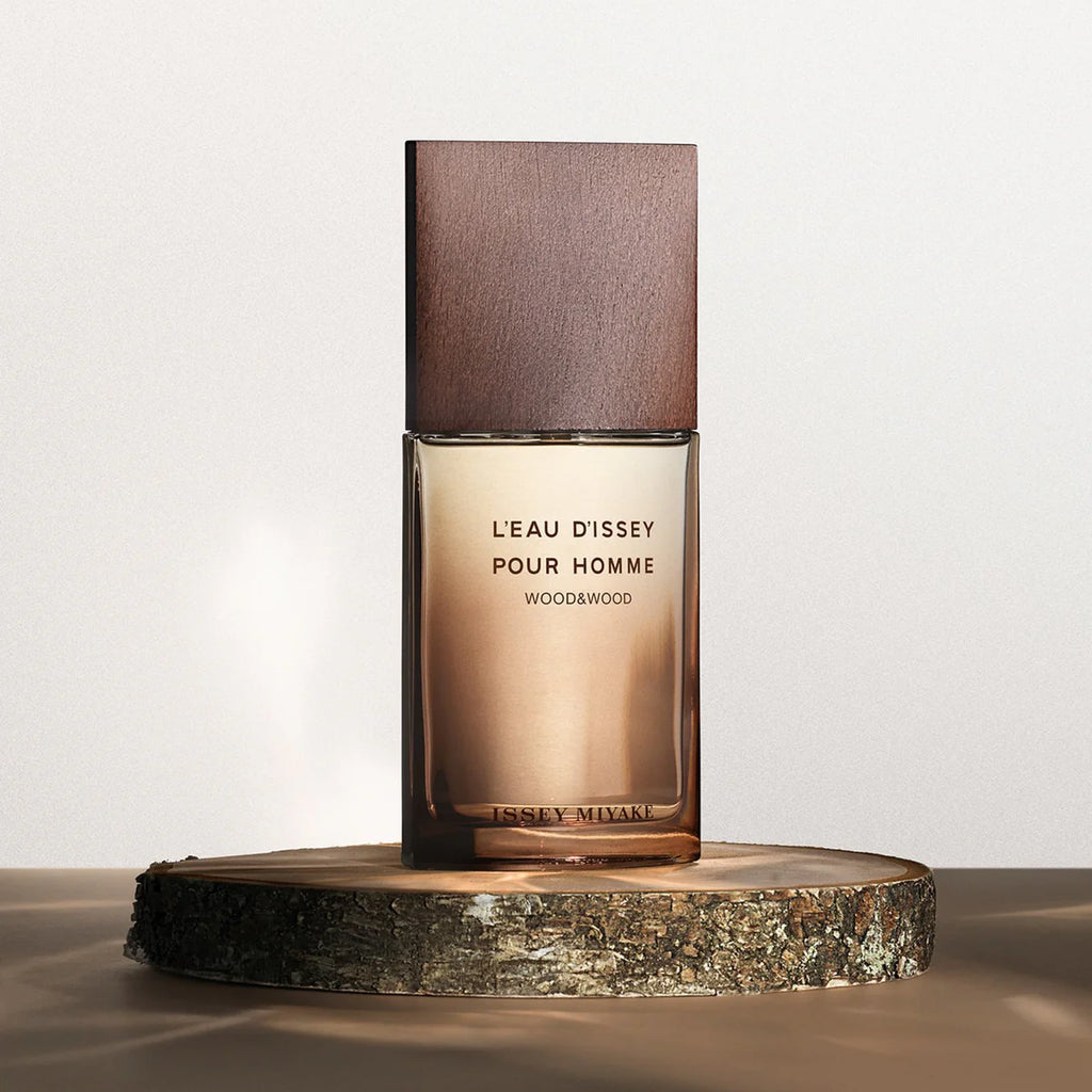Perfume bottle with wooden cap on a wooden platform against a light background