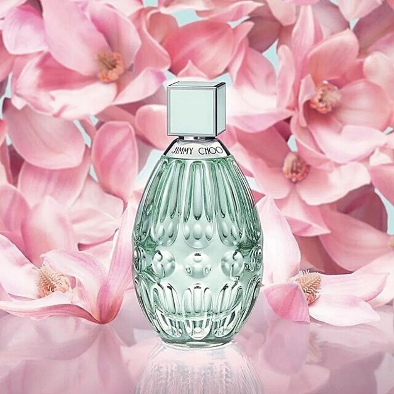 Perfume bottle with pink flowers in the background