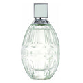 Clear glass perfume bottle with silver cap on a white background