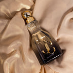 Perfume bottle with gold cap on beige fabric