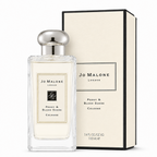 Jo Malone London Peony & Blush Suede Cologne perfume bottle in a clear glass rectangular shape with a silver cap, shown next to its cream-colored packaging box with black trim.