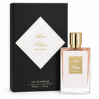 A bottle of Love by Kilian Eau de Parfum with a gold cap and a clear glass body showing a pale pink liquid, standing next to its black textured packaging box with a white diamond label.